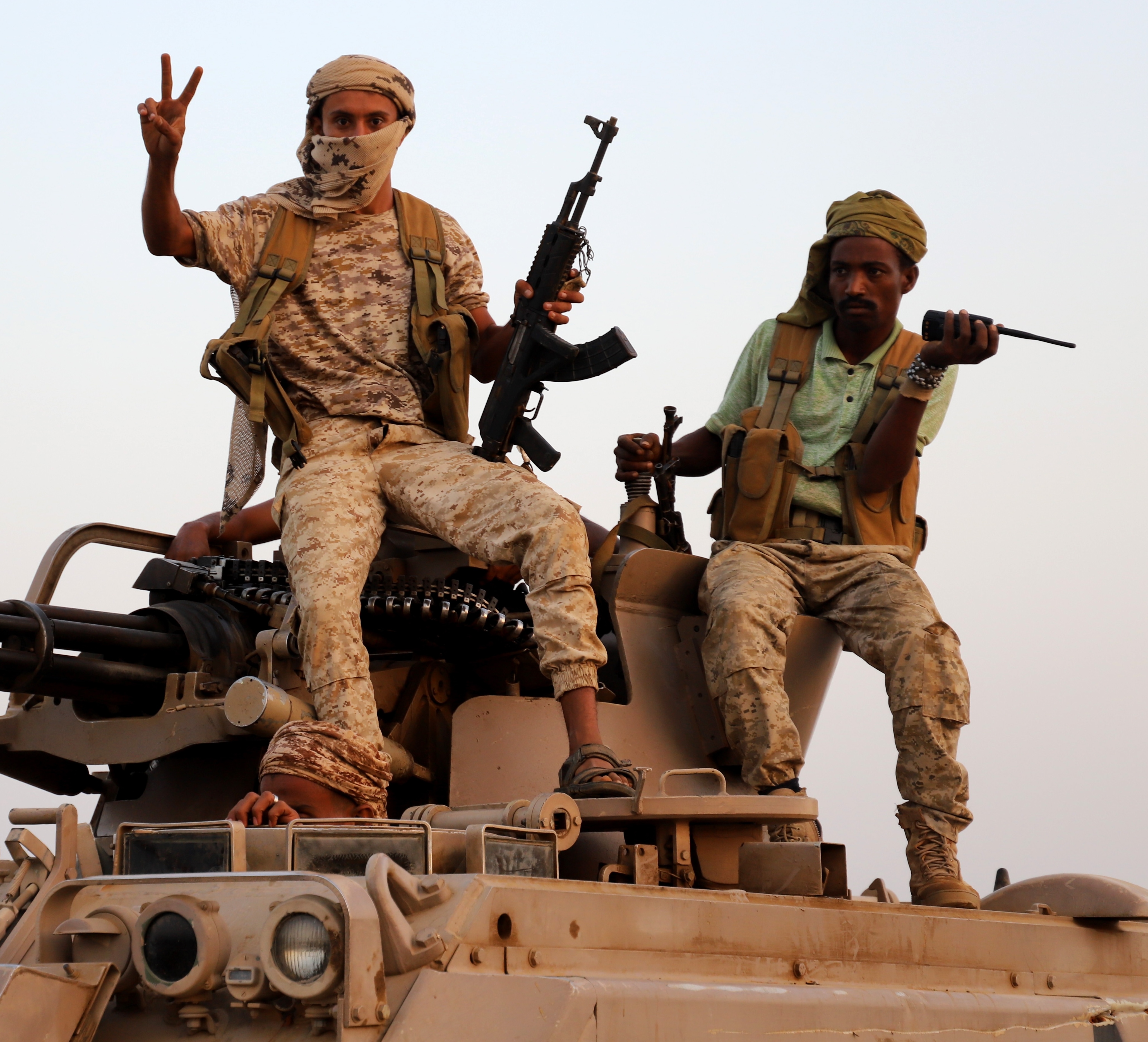 Armed Yemeni government fighters sit on a military vehicle during fighting in Hajjah Governorate.