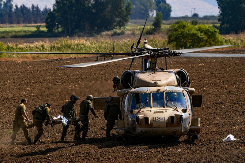 Israeli soldiers evacuate wounded person who was injured from a missile fired from Lebanon, near the Israeli border with Lebanon, October 22, 2024.