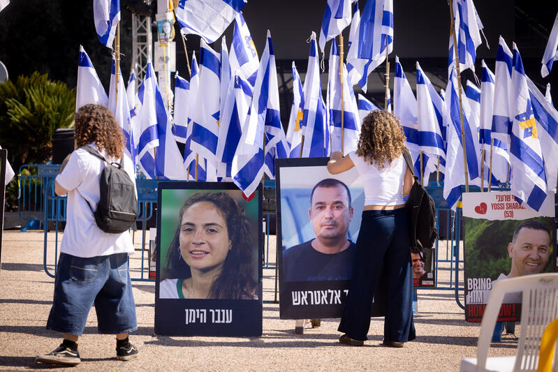 Posters of hostages displayed among Israeli flags at Hostage Square in Tel Aviv.