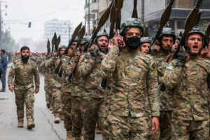 Armed Syrian soldiers marching in formation with rocket-propelled grenade launchers.