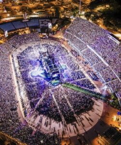A large crowd fills a stadium during an Omer Adam concert.