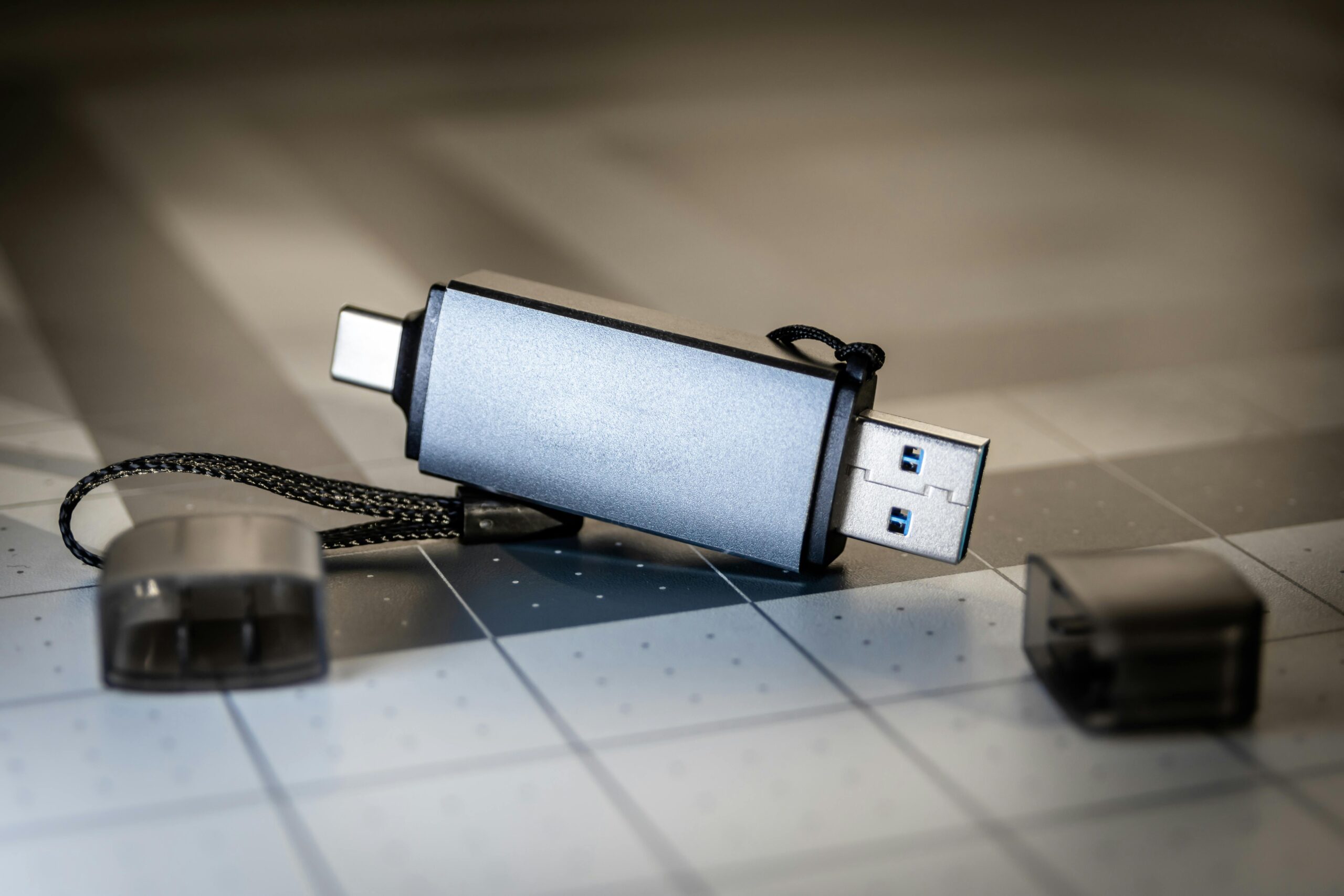 High-quality close-up of a dual USB-C and USB-A flash drive on a sleek grid-patterned background