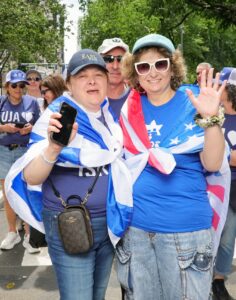Pro-Israel supporters wrapped in Israeli and American-themed flags at a public event.