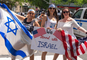 Pro-Israel supporters holding Israeli and American flags at a public demonstration.