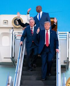 President Donald Trump disembarks Air Force One in South Carolina with Lindsey Graham behind him.