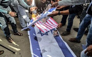 Protesters burning American and Israeli flags during a demonstration in Gaza.