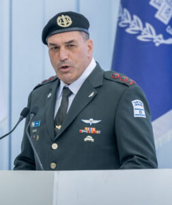 IDF Chief of Staff Eyal Zamir speaks at a podium with Israeli flags behind him.