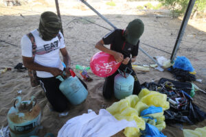 Palestinian men preparing balloons and equipment near Rafah along the Israel-Gaza border.