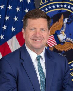 Official portrait of Director of National Intelligence Jay Clayton in front of U.S. flags and the ODNI seal.