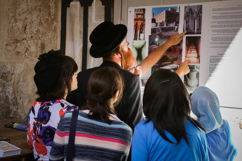 Jews looking at sign with archaeological findings outside the Cave of the Patriarchs, Hebron