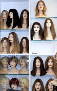 Women’s wigs displayed on shelves.