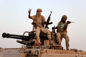 Armed Houthi fighters sit on a military vehicle in Hajjah Governorate, Yemen.