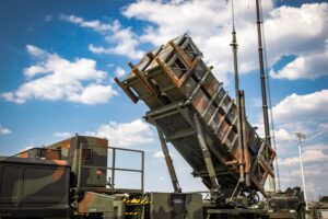 A Patriot air defense missile launcher positioned under a cloudy sky.