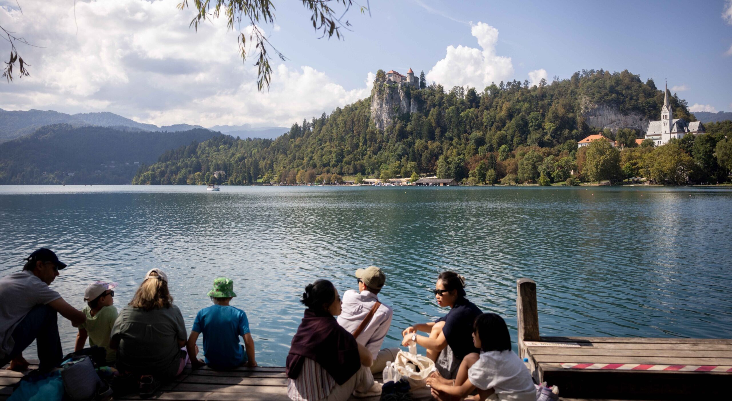 People sit by Lake Bled in Slovenia.