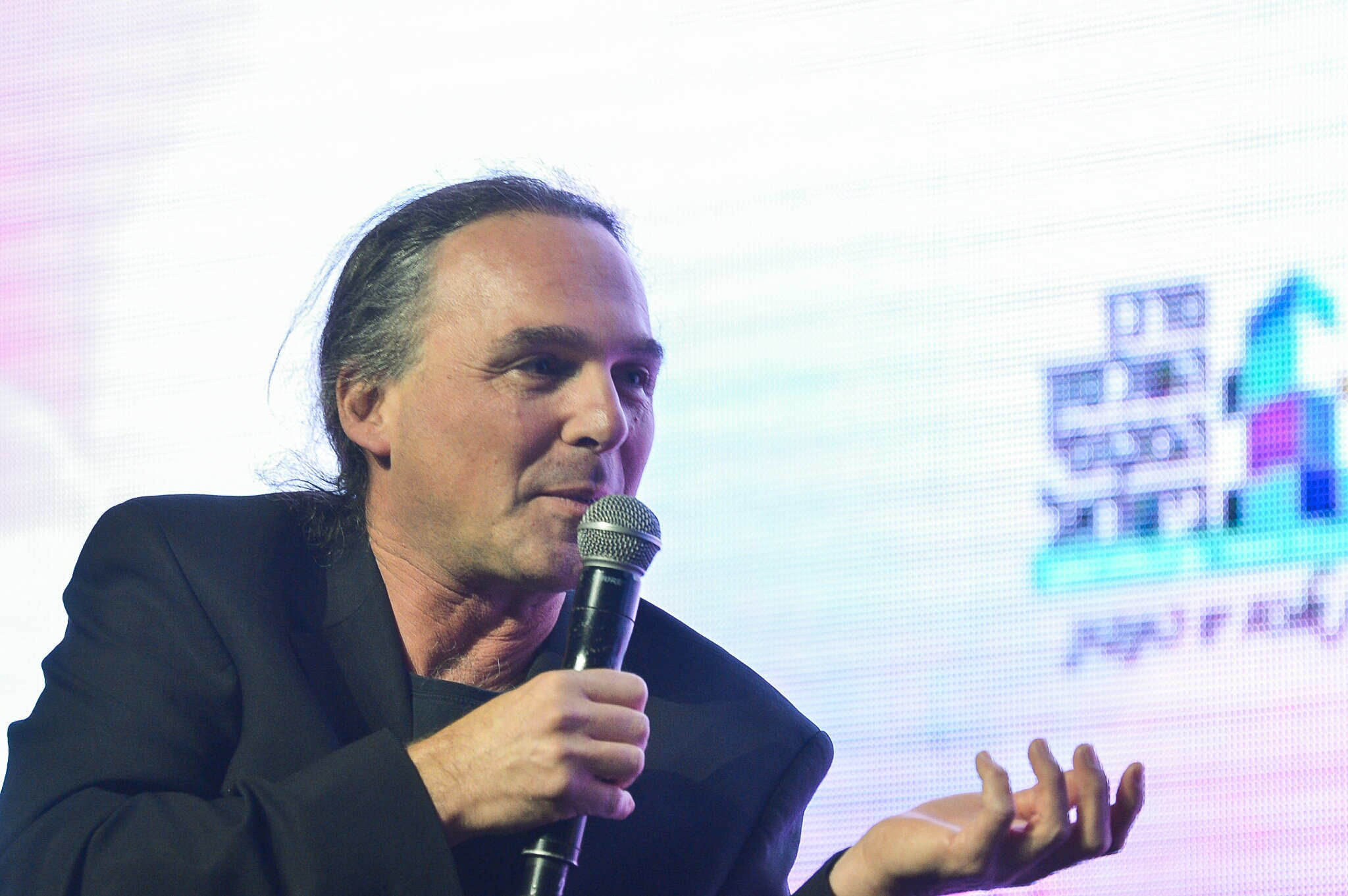 Israeli journalist Avishay Ben Haim speaks into a microphone at a conference in Tel Aviv.