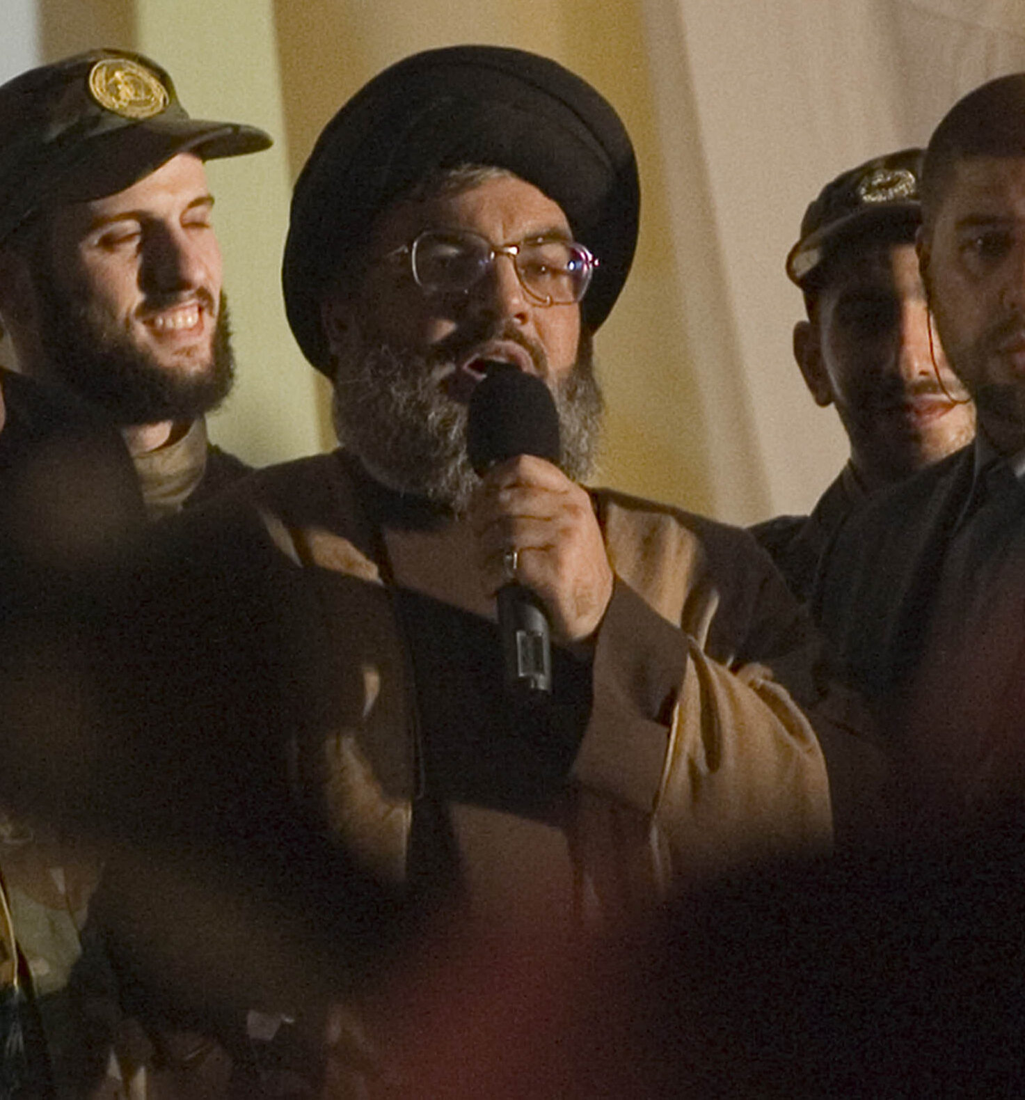 Hezbollah leader Hassan Nasrallah speaks into a microphone during a public appearance.