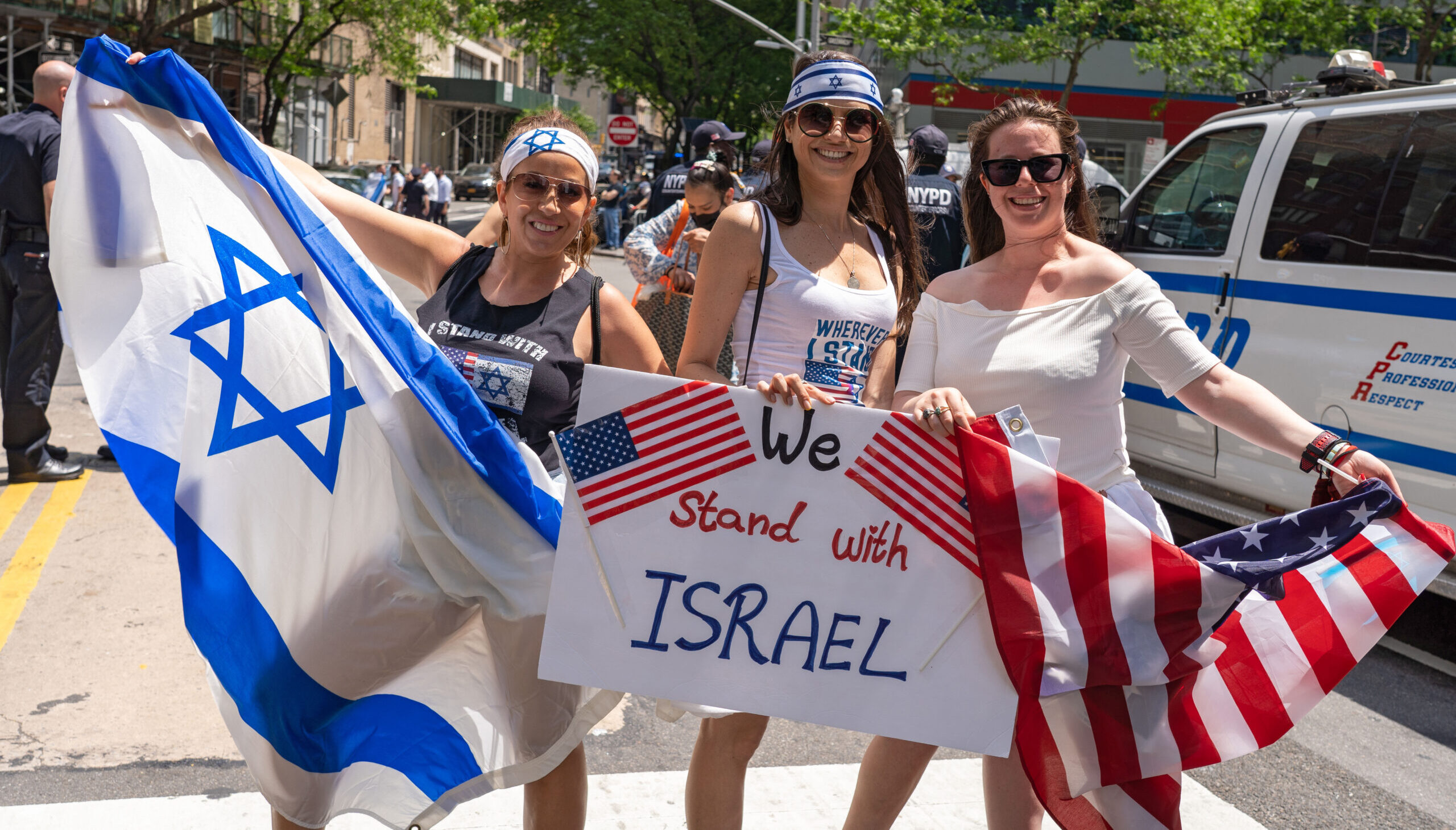 Pro-Israel supporters holding Israeli and American flags at a public demonstration.