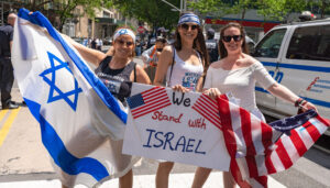 Pro-Israel supporters holding Israeli and American flags at a public demonstration.