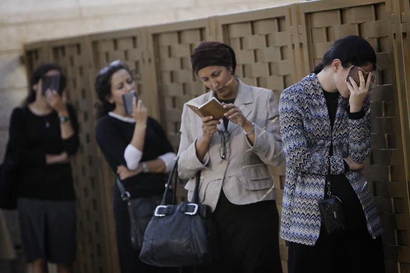 Women praying with prayer books at Western Wall (kotel)