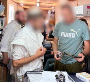 Israeli soldiers helping prepare tefillin during a Torah aliyah ceremony on base.