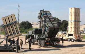 Israeli soldiers walk near Iron Dome, Patriot, and Arrow 3 missile-defense systems at Hatzor Air Force Base.