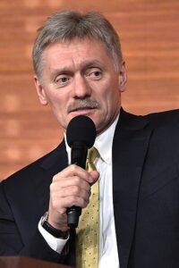 Kremlin spokesman Dmitry Peskov speaking into a microphone during a press conference.