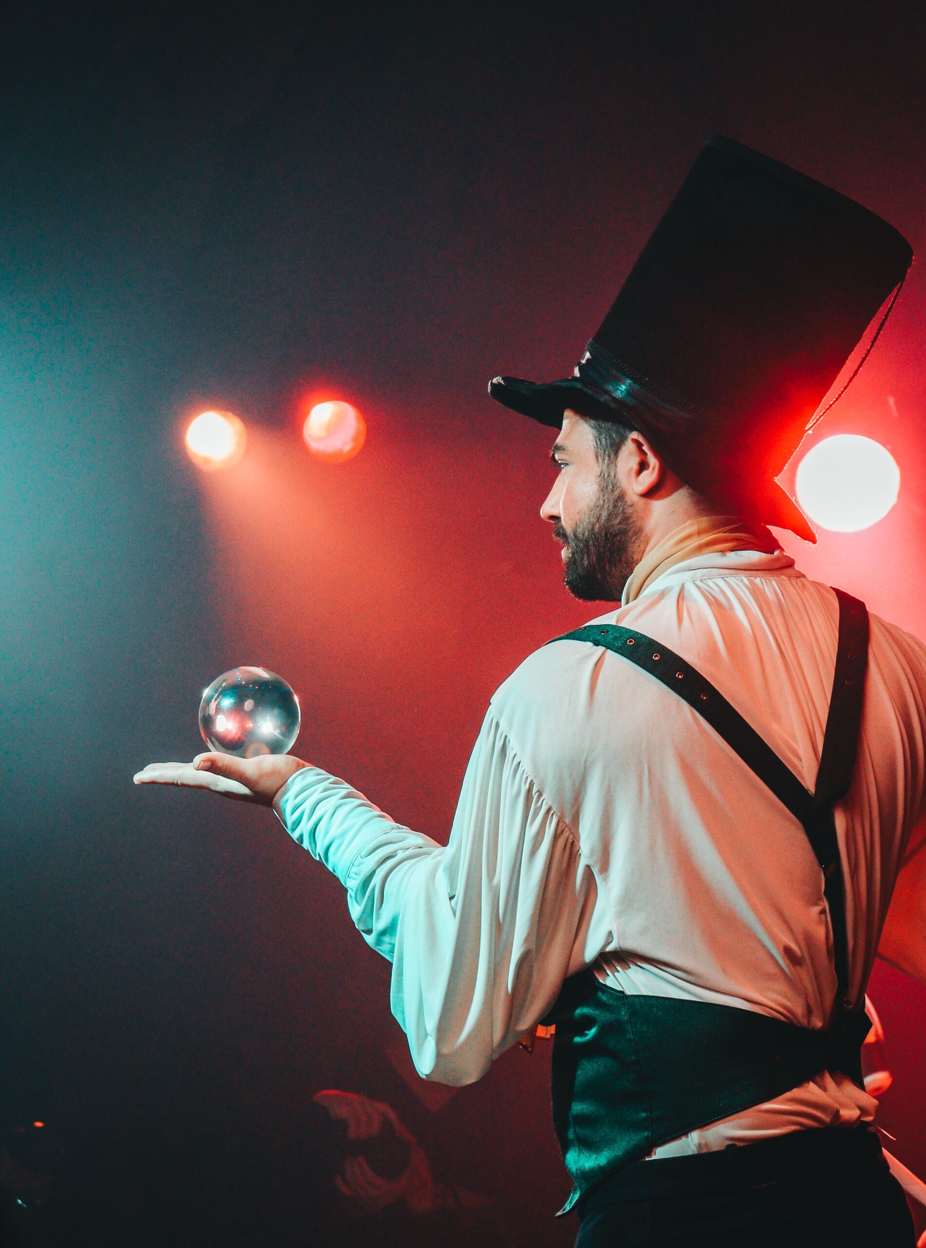 magician in on stage with tall black hat and crystal ball