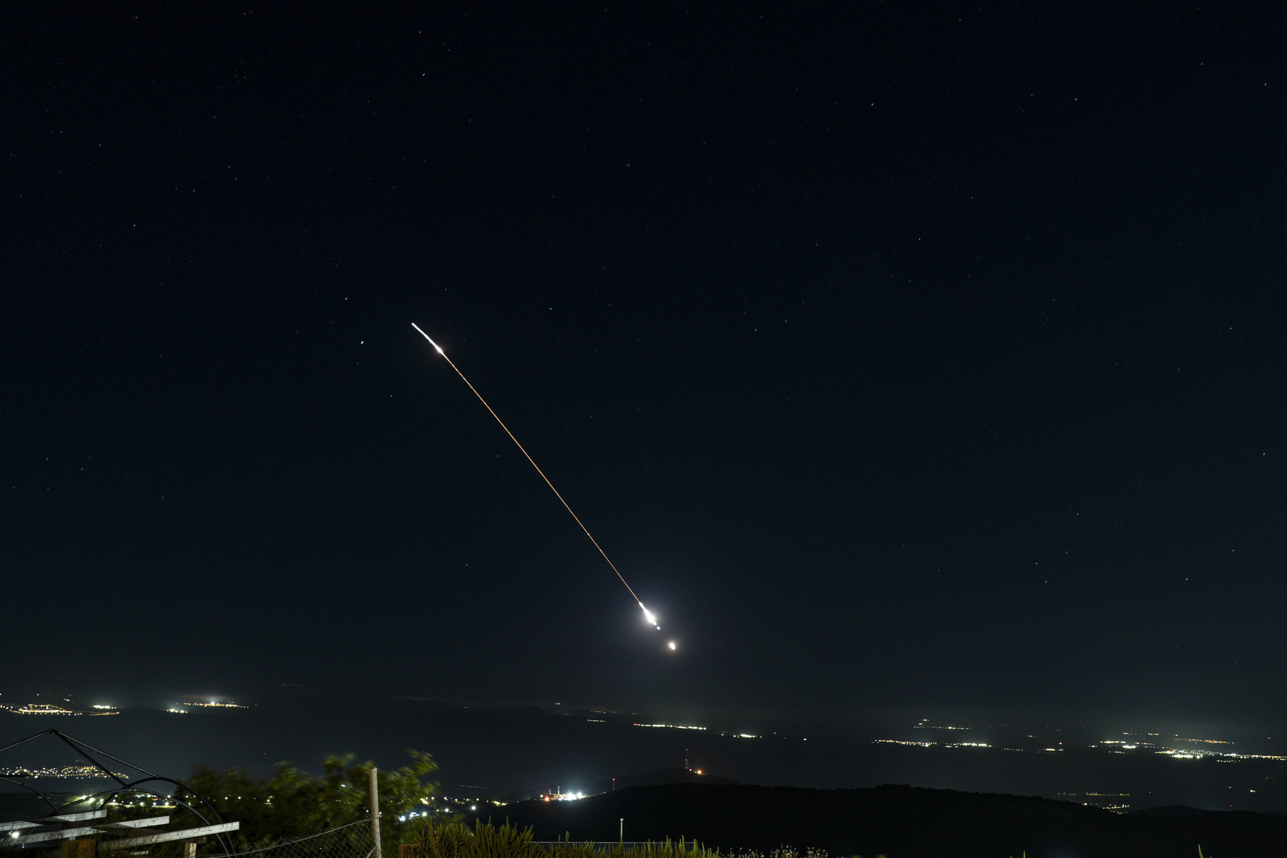 Anti-missile batteries fire interception missiles over northern Israel at night.