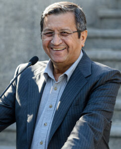 Abdolnaser Hemmati smiling while speaking at a microphone.