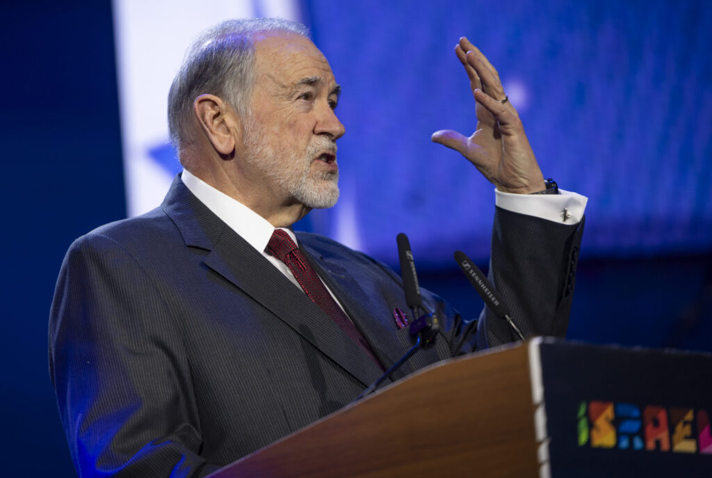 U.S. Ambassador to Israel Mike Huckabee speaking at a podium during the FOZ Ambassadors Summit in Jerusalem.
