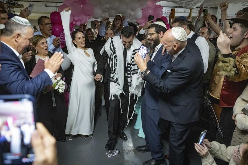 An Israeli couple stands during wedding ceremony held in an underground parking lot during war with Iran. March, 2026.