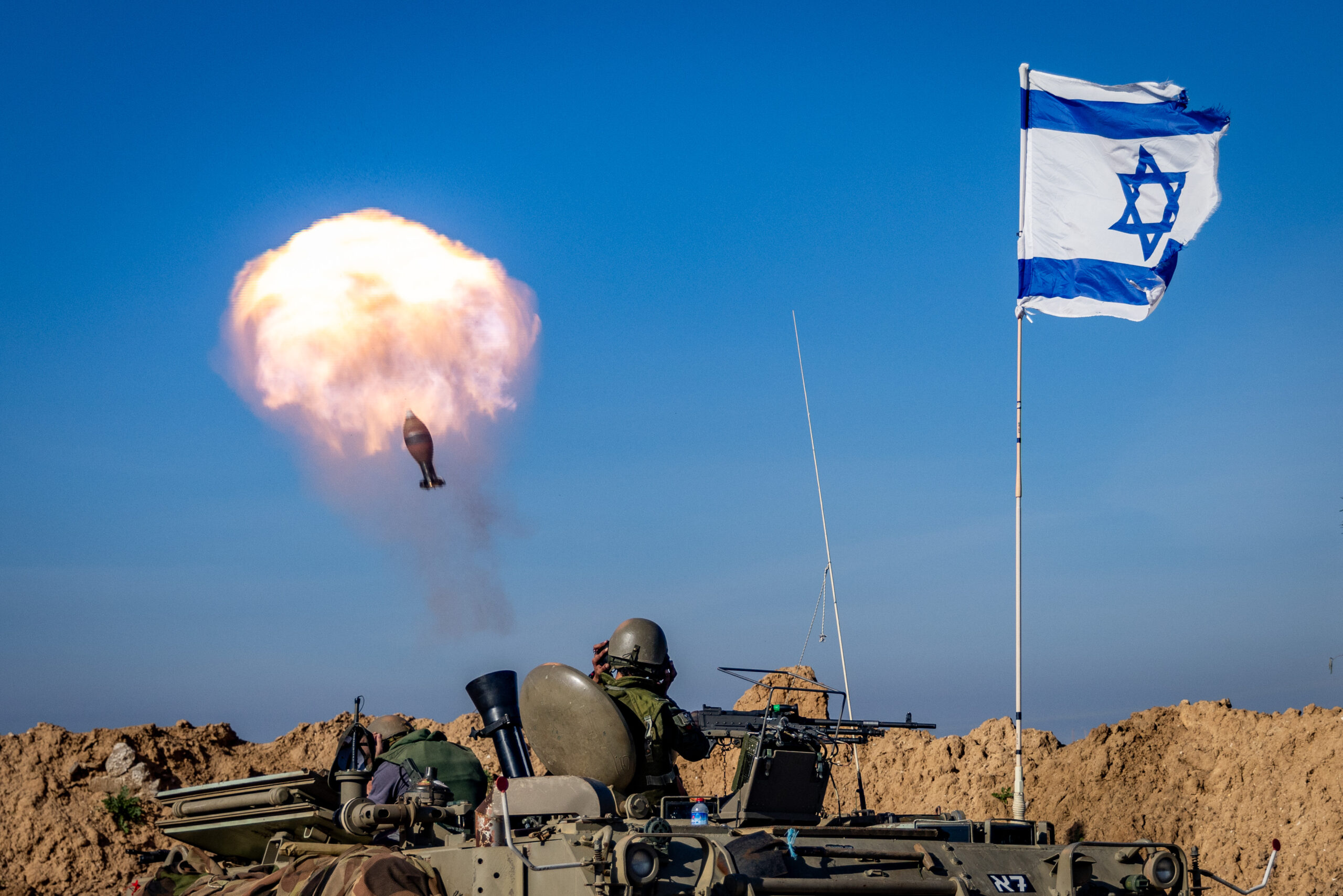 Israeli soldiers fire mortar shells during military activity.