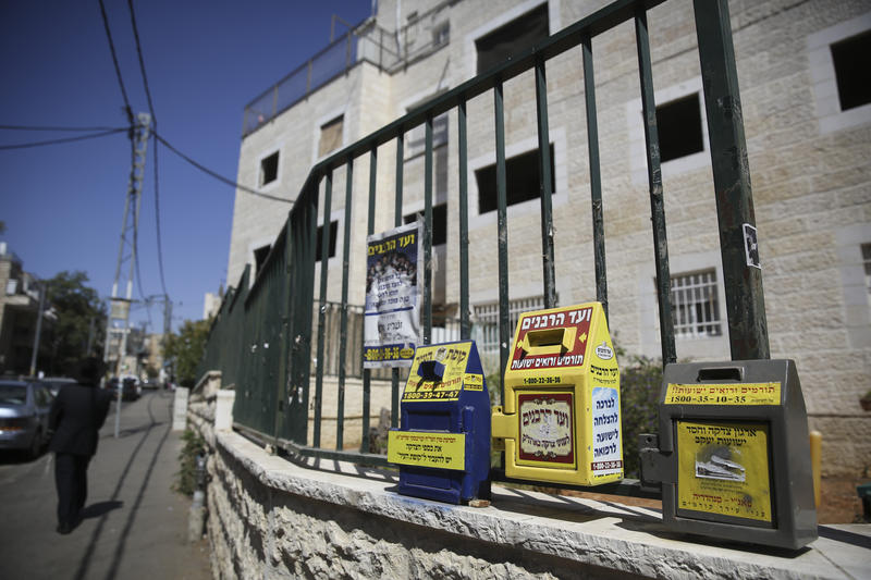tzeddakah boxes on a fence in jerusalem neighborhood. 