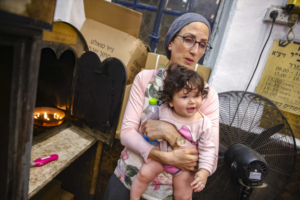 Mother of missing teen Moishe Kleinerman holds a child near the Tomb of Rabbi Shimon bar Yochai in Meron.