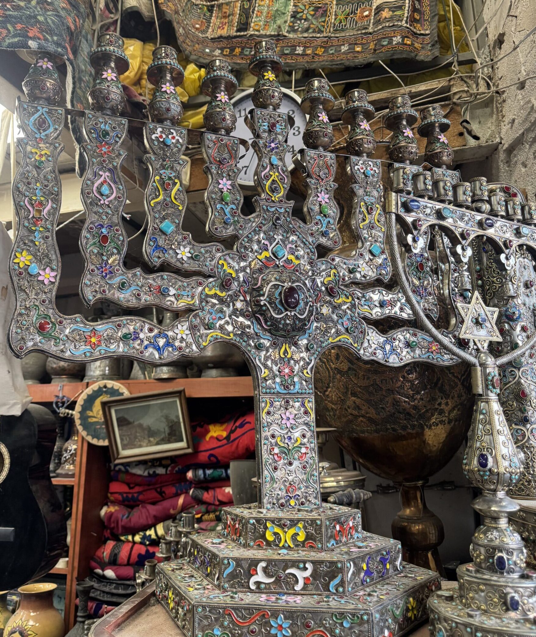 Decorative silver Chanukiah with colorful enamel details displayed in a shop in the Jaffa Flea Market.