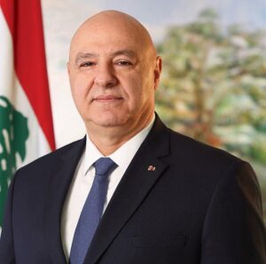 Lebanese President Joseph Aoun standing beside the Lebanese flag