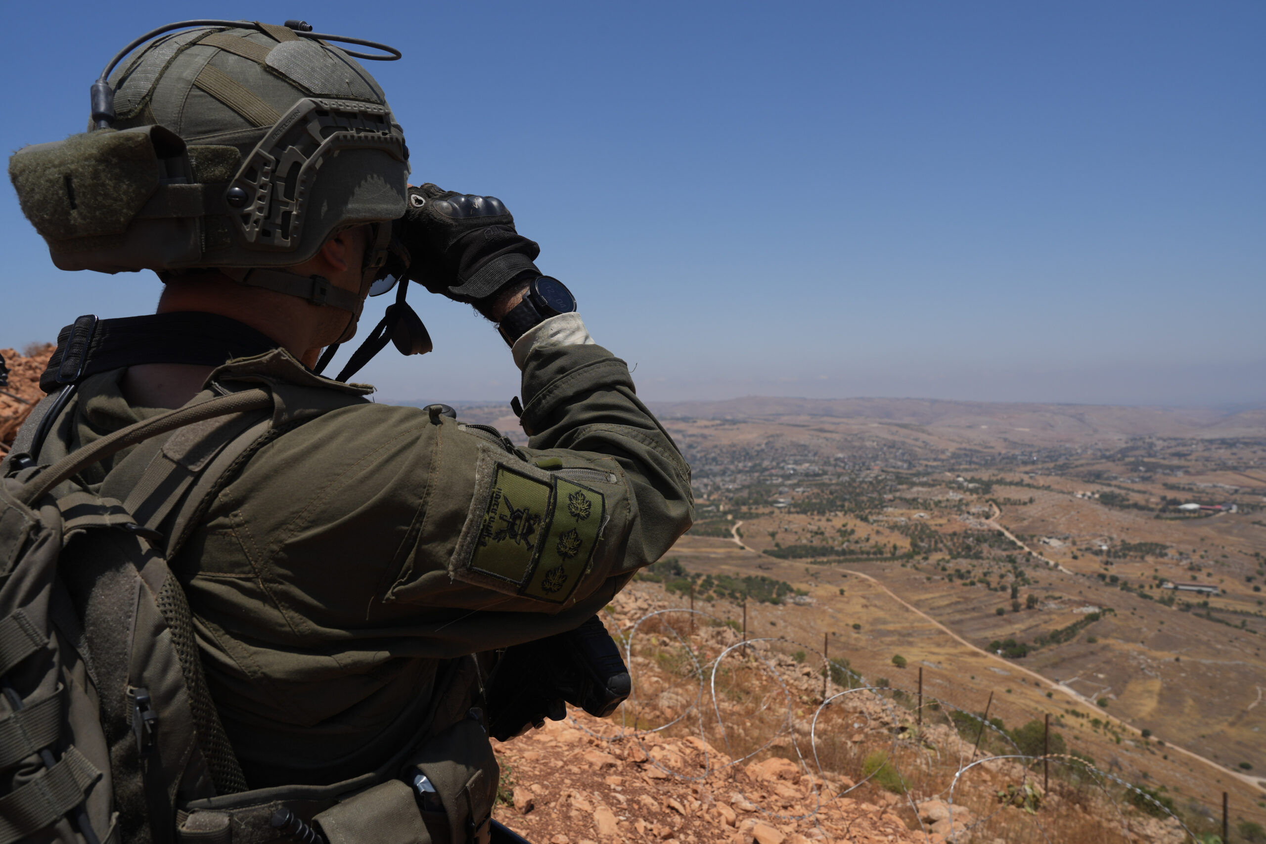 An Israeli soldier looks through binoculars on the northern border with Lebanon.