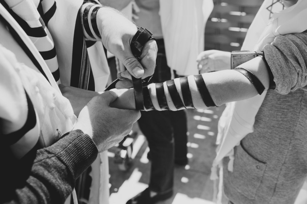 Wrapping tefillin on arms and head |