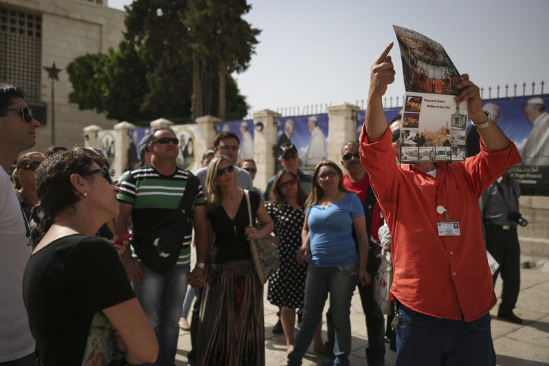 A guide leads a group of tourists in Bethlehem, Israel.