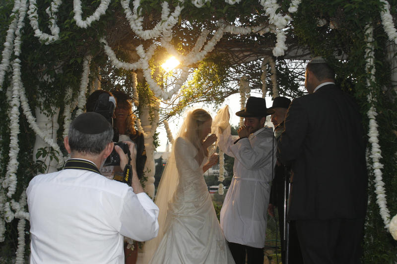 traditional jewish bride and groom under chuppah, drinking kiddush wine