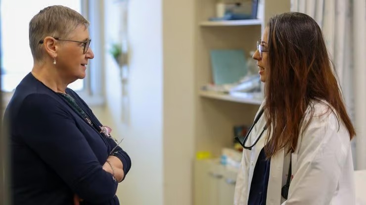 Dr. Mira Wollner speaks with a doctor in a hospital setting.