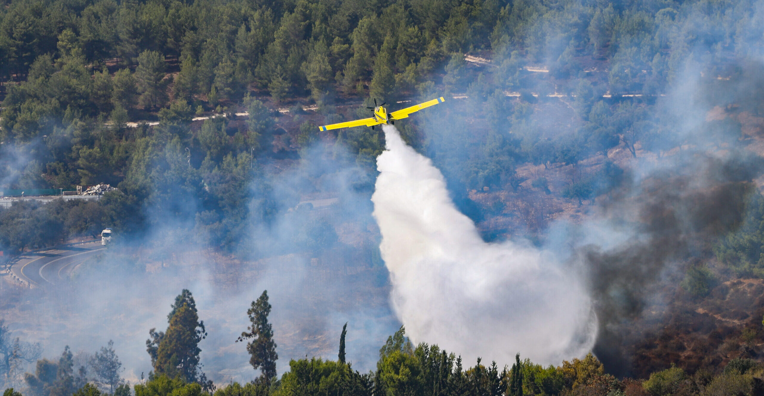 A firefighting plane drops fire retardant over a forest in northern Israel after missiles from Lebanon.
