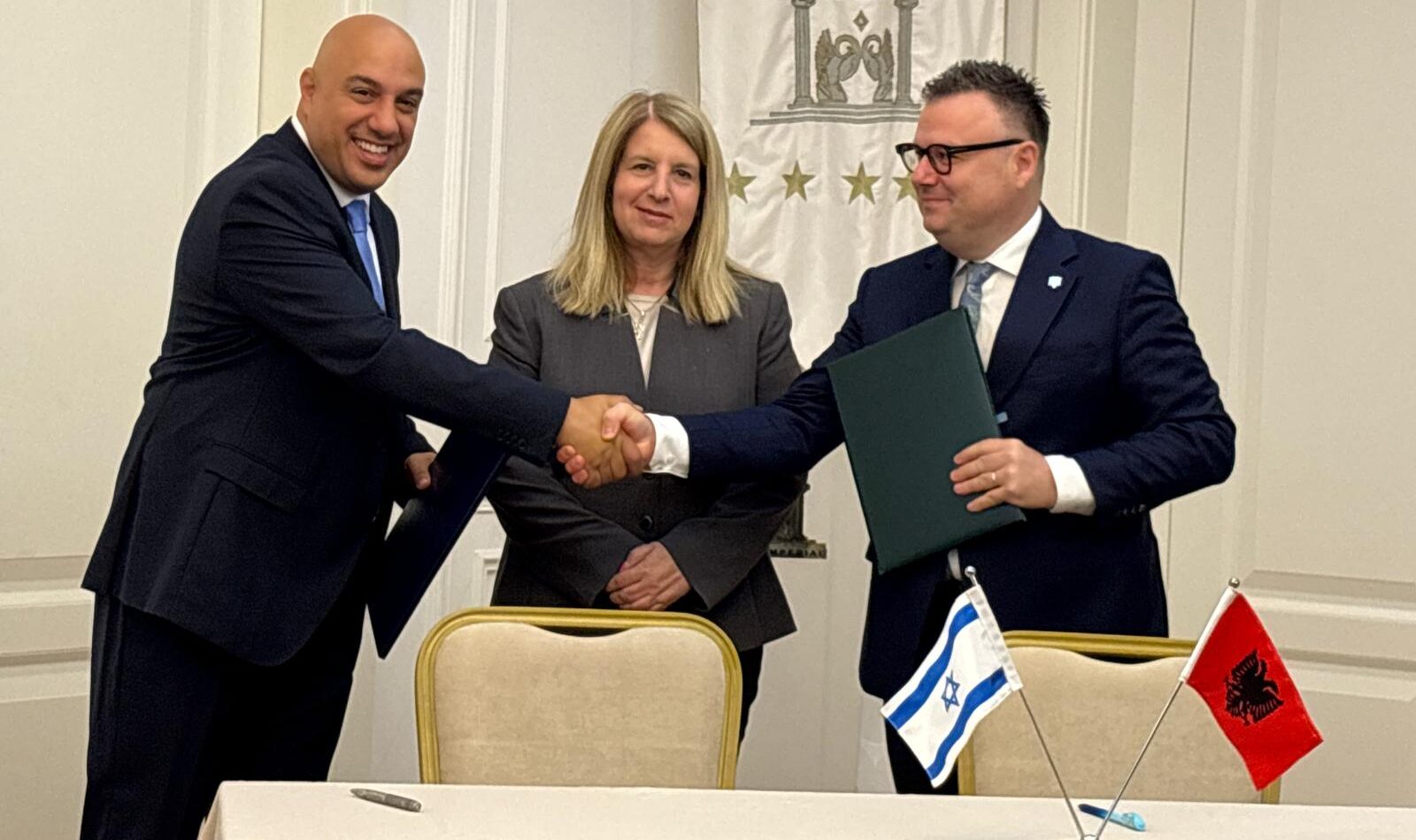 Israeli and Albanian officials shake hands after signing an agricultural cooperation agreement.