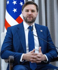 U.S. Vice President JD Vance speaking beside an American flag during a meeting in Jerusalem